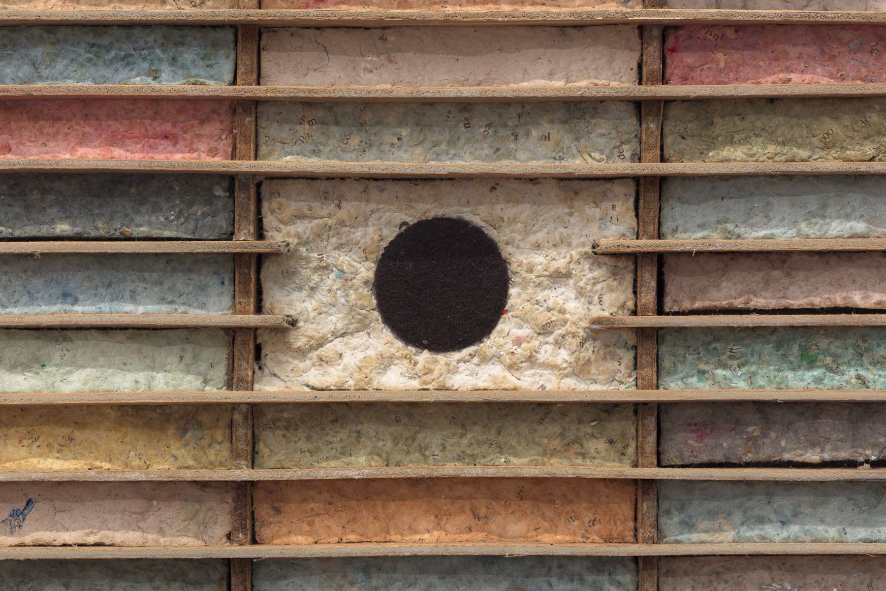 Bronson Smillie. Debris Flow Hotel (Detail), 2023. Modified cassette storage case, paper pulp, bar rag, postage stamp, felt pad. 18.5 x 24 x 3 inches.