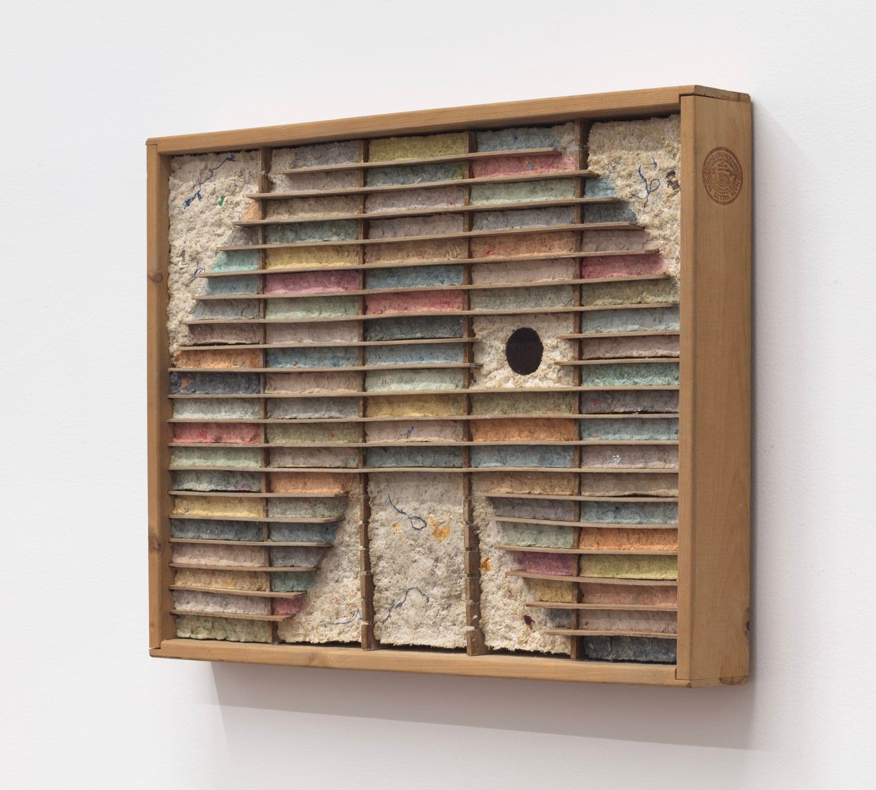 Bronson Smillie. Debris Flow Hotel, 2023. Modified cassette storage case, paper pulp, bar rag, postage stamp, felt pad. 18.5 x 24 x 3 inches.