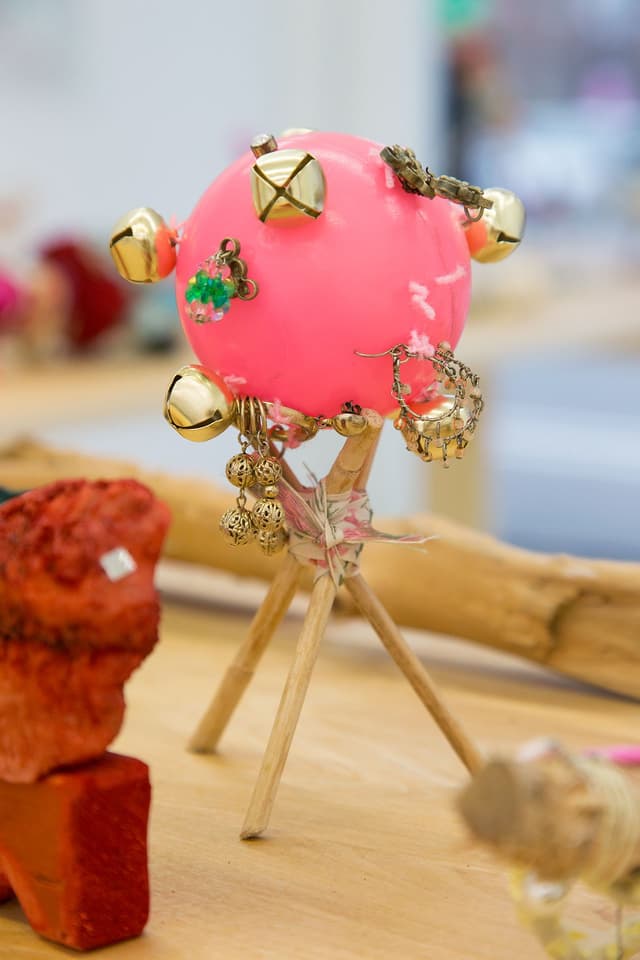 Alix Van Der Donckt-Ferrand. Untitled, 2022. Dog chewed ball, bells, earrings, cattail, ribbon. 7.5 x 4 x 4 inches.