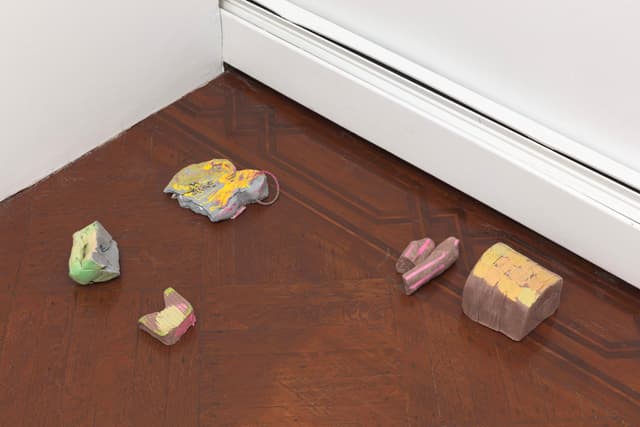 Laura McCoy. Capital Problem, 2022. Clay, acrylic paint, plastic, flowers. Dimensions variable.