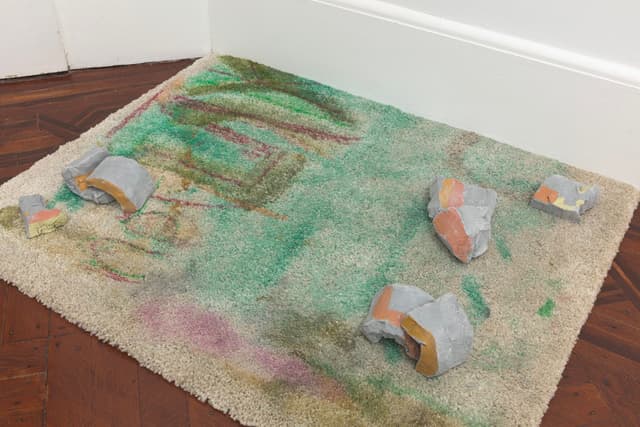 Laura McCoy. Gertrude No Comma, 2022. Carpet, clay, acrylic paint. 3 x 31 x 25 inches.