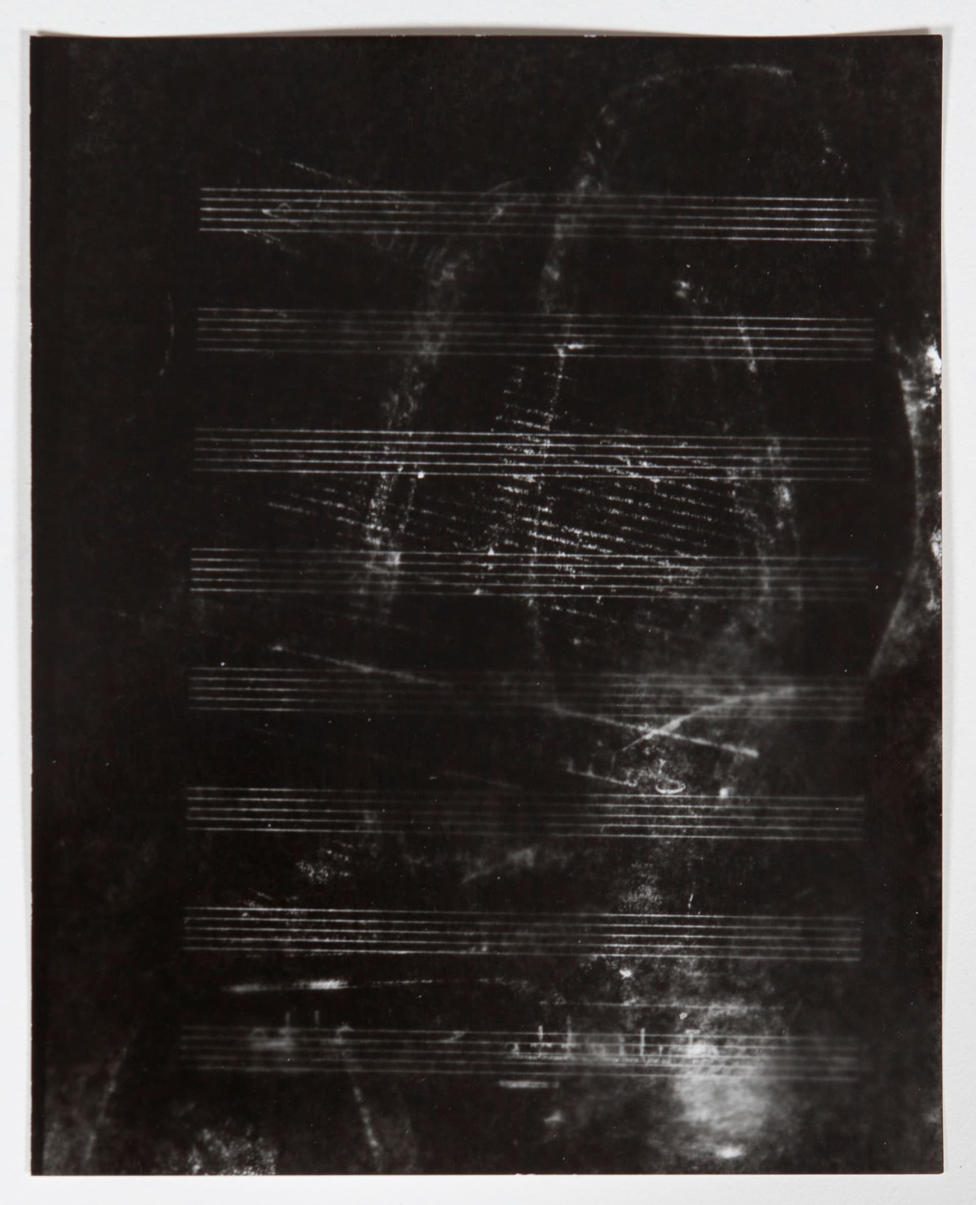 Mo Costello. Untitled (Score), 2022. Gelatin Silver Contact Print made from paper negative (xerox copy of ink rubbing made with recalled ROTC footware on sheet music). 8 x 10 inches.
