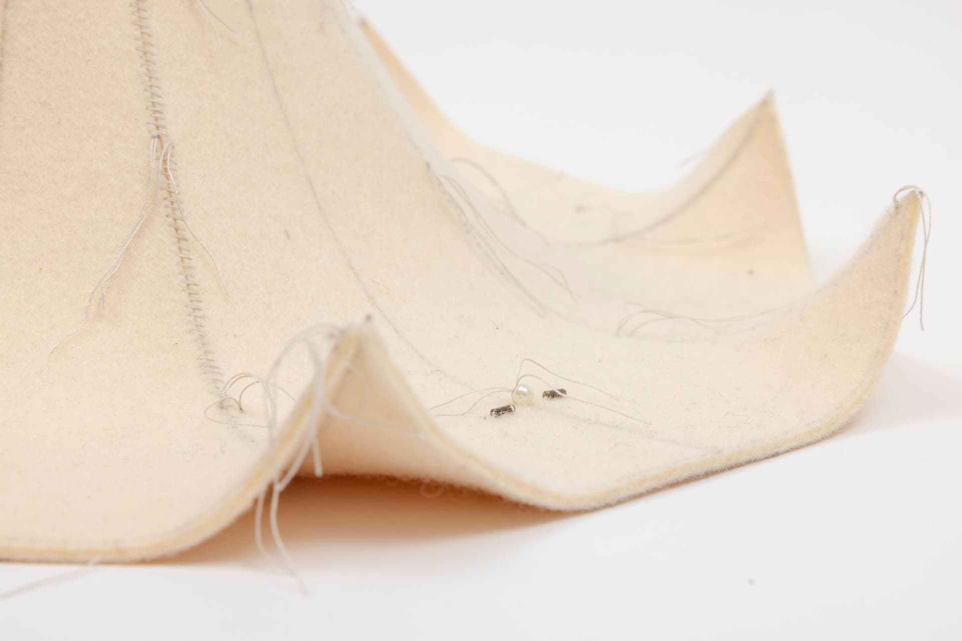 Cyrilla Mozenter. More saints seen 18 (Detail), 2004. Pencil on industrial wool felt hand stitched with silk thread, wooden craft stick and toothpick, button, pearls, and bugle beads. 13.5 × 16 × 16 inches.