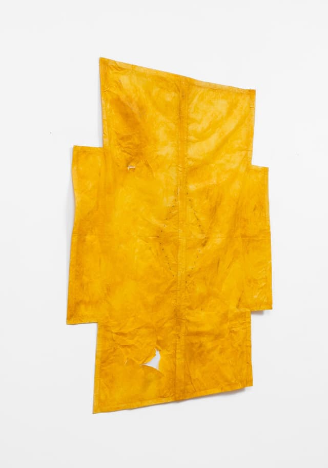 Faye HeavyShield. a cruciform, 2026. Gesso, yellow oxide, graphite, and tape on paper. 45 3/4 × 36 inches.