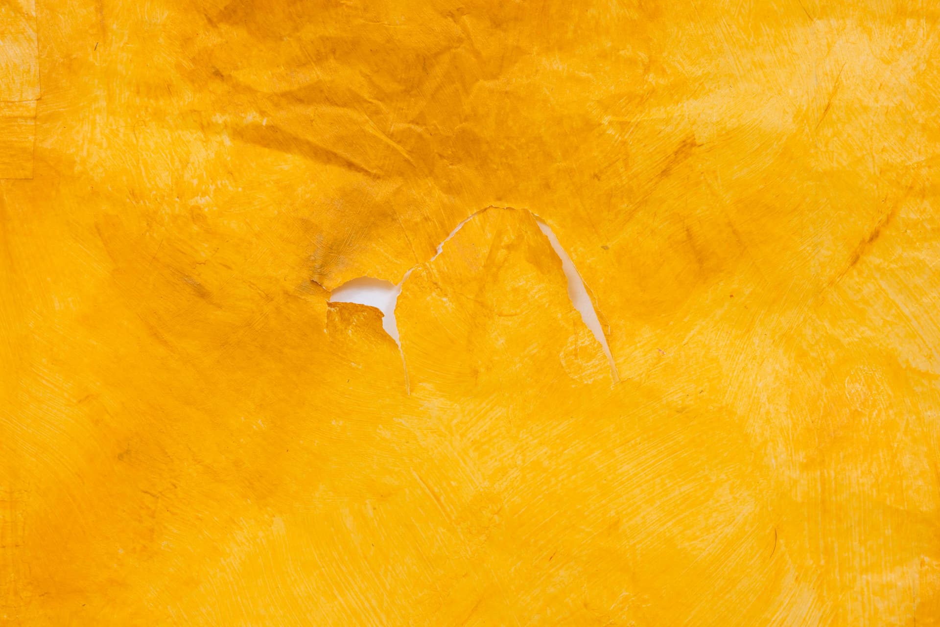 Faye HeavyShield. a cruciform (Detail), 2026. Gesso, yellow oxide, graphite, and tape on paper. 45 3/4 × 36 inches.