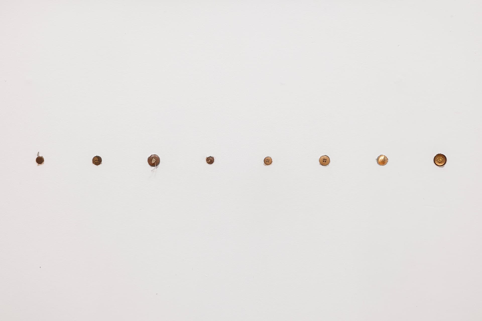 Bronson Smillie. <i>Button chair rail (no repeats)</i>, 2026. Buttons. Dimensions variable.
