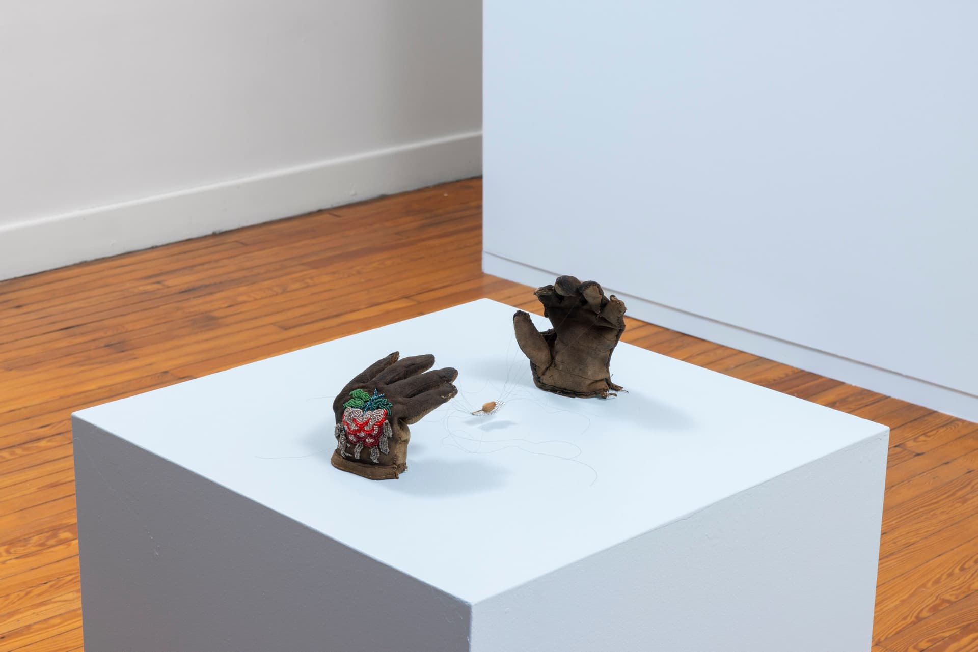 Audie Murray. <i>Net Weavers; ○</i>, 2026. Glass beads, artist's hair, tobacco, reutilized beadwork from unknown artist. 7 × 6 × 16 inches.