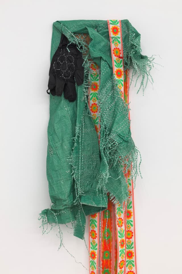Jeneen Frei Njootli. Lisa, 2022 (Detail). Green Tarp, gloves, staples, ribbon, plywood. 30 x 18 x 3 inches / Variable upon installation.