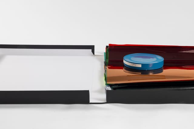 Margaret Honda. Retired Work (Detail), 2021-2023. Film (Fluentum), 2021, 36 Rosco and Lee lighting gels, 4-page score; Wildflowers (NG), 2015, color composite 16mm film print, 100 feet on core in can; Film (Basel Social Club), 2023, 236 Polyester gels, 5-page score. 2.375 × 24.875 × 43.375 inches. Courtest of the artist and Galerie Molitor, Berlin.