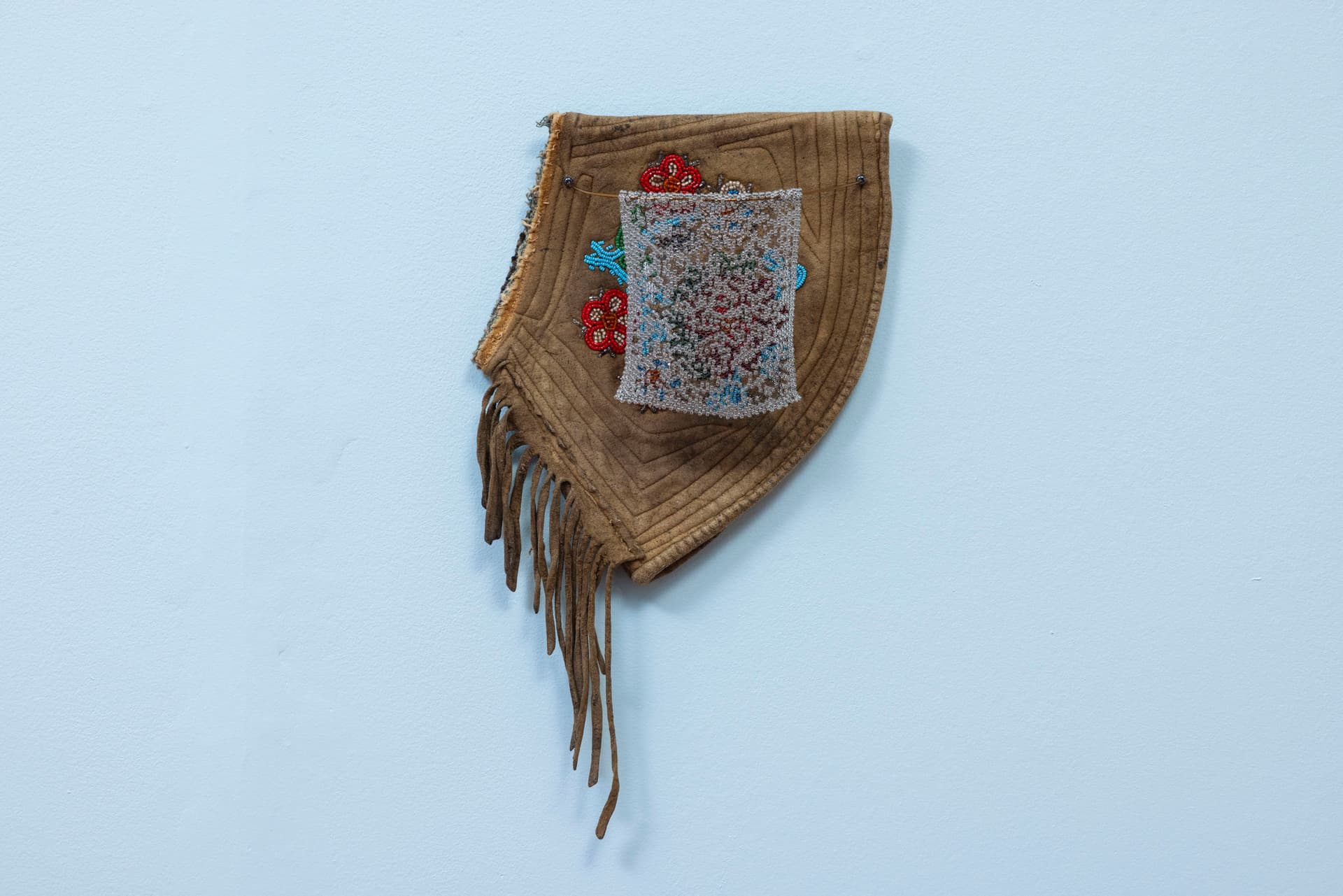 Audie Murray. <i>Net Charm; <</i>, 2025. Glass beads, thread, copper, reutilized beadwork from an unknown artist. 13 × 8 × 3 inches.