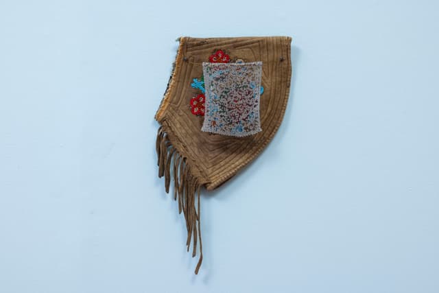 Audie Murray. <i>Net Charm; <</i>, 2025. Glass beads, thread, copper, reutilized beadwork from an unknown artist. 13 × 8 × 3 inches.