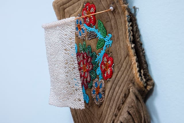 Audie Murray. Detail of <i>Net Charm; ></i>, 2025. Glass beads, thread, copper, reutilized beadwork from an unknown artist. 13 × 8 × 3 inches.