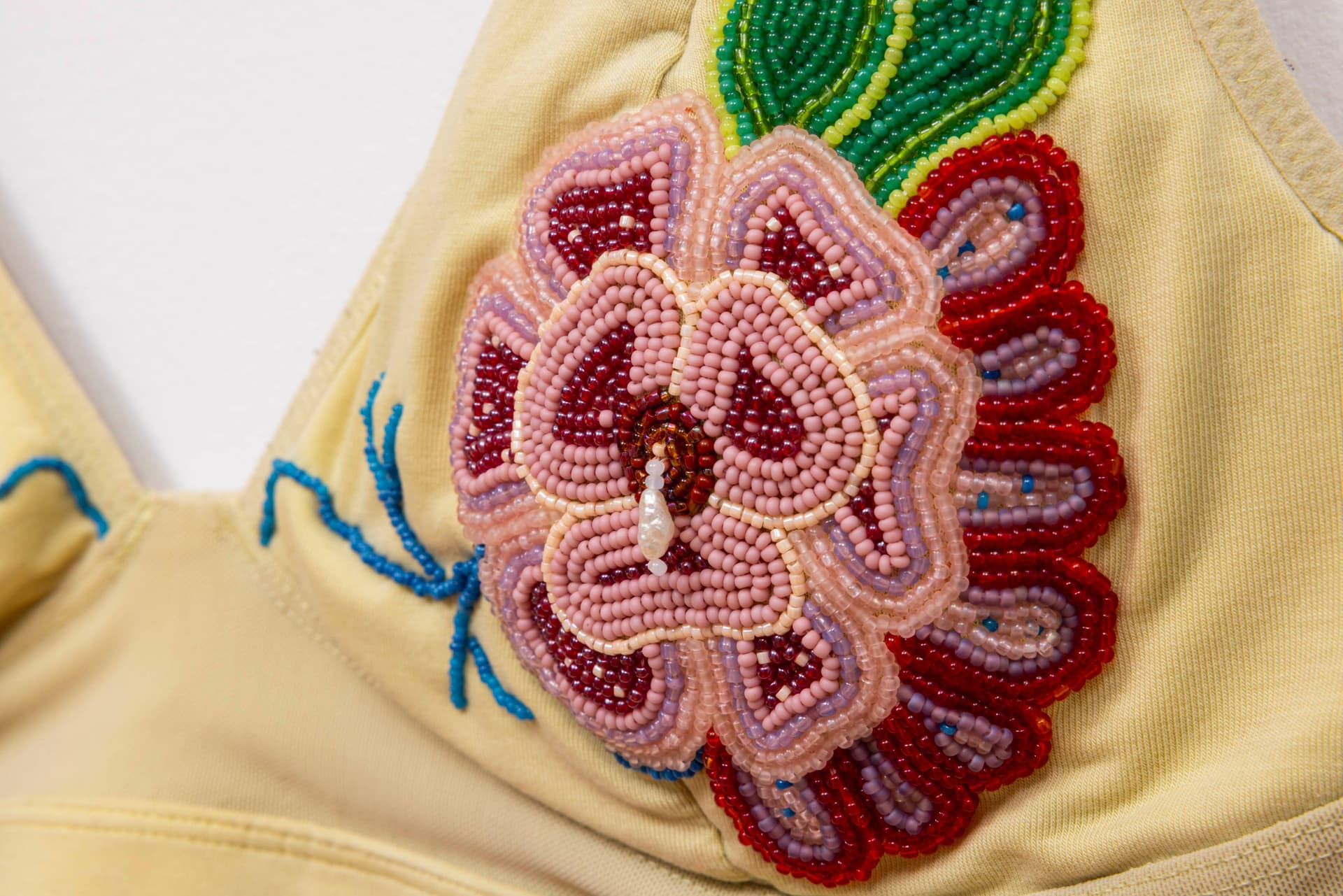 Audie Murray. Detail of <i>Old Bra</i>, 2026. Worn bralette, glass beads, copper. 12 × 15 inches.