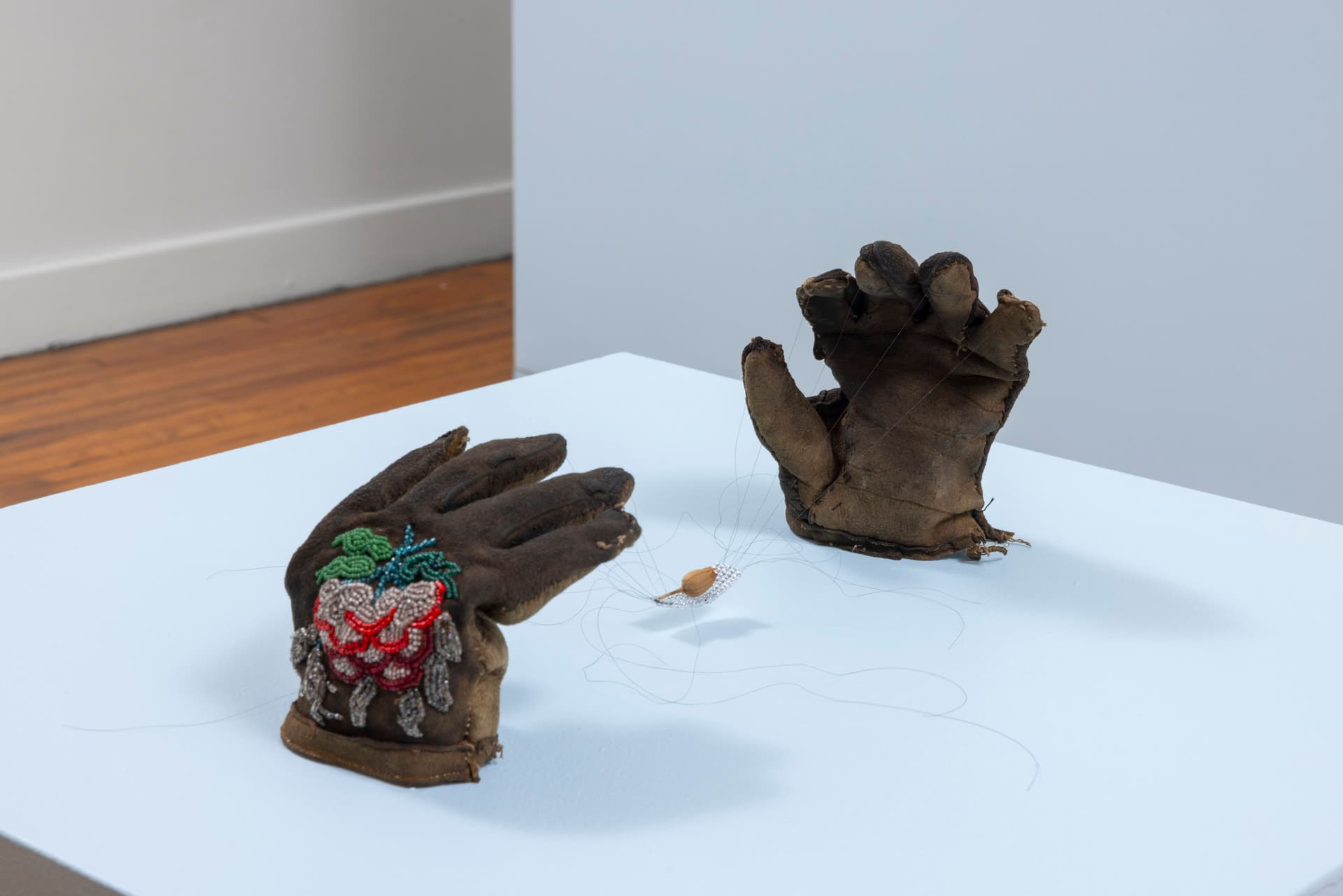 Audie Murray. <i>Net Weavers; ○</i>, 2026. Glass beads, artist's hair, tobacco, reutilized beadwork from unknown artist. 7 × 6 × 16 inches.