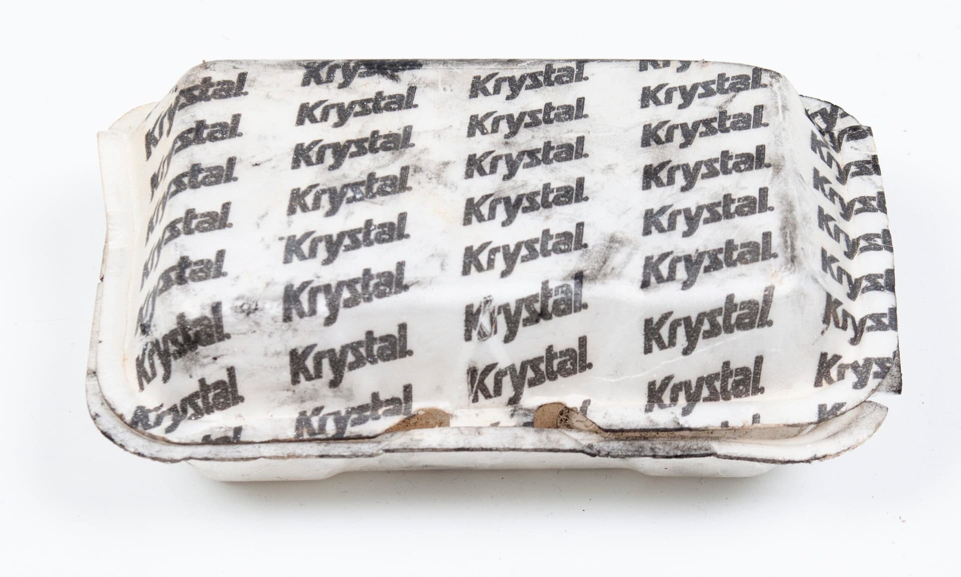 Mo Costello. Untitled (Dice), 2021. Soot and Found Objects (Rolaids (2) in Krystal's Styrofoam Take-Out Container). 7 x 4 x 2 inches.