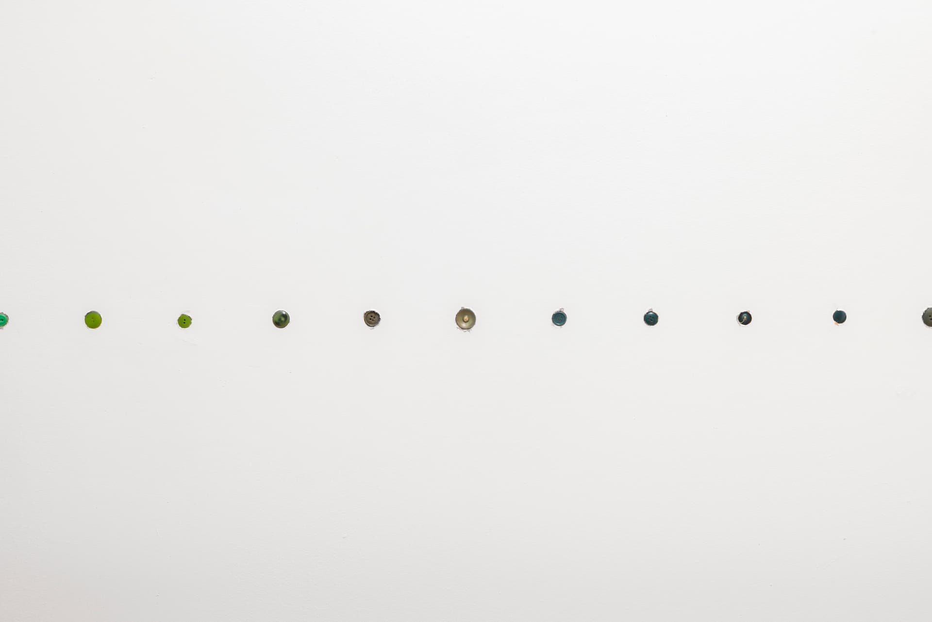 Bronson Smillie. <i>Button chair rail (no repeats)</i>, 2026. Buttons. Dimensions variable.