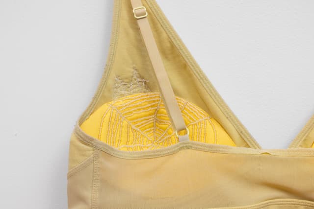 Audie Murray. Detail of <i>Old Bra</i>, 2026. Worn bralette, glass beads, copper. 12 × 15 inches.
