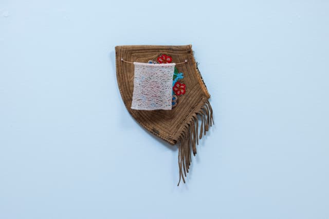 Audie Murray. <i>Net Charm; ></i>, 2025. Glass beads, thread, copper, reutilized beadwork from an unknown artist. 13 × 8 × 3 inches.