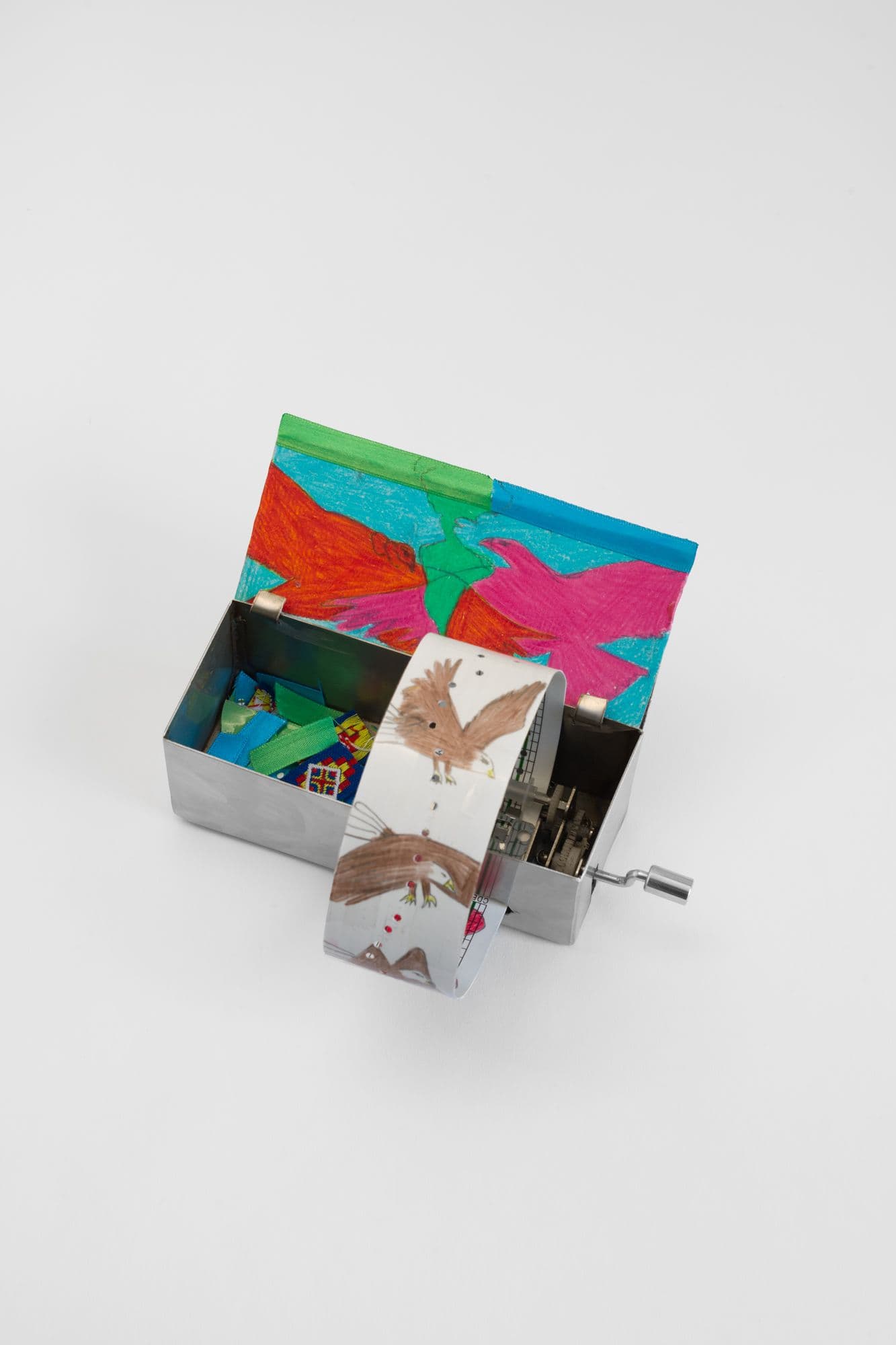 Alix Van Der Donckt-Ferrand. Eagle and Condor Prophecy, 2025. Color pencil and graphite on paper, ribbons, steel music box. 5.5 x 2.25 x 2 inches.
