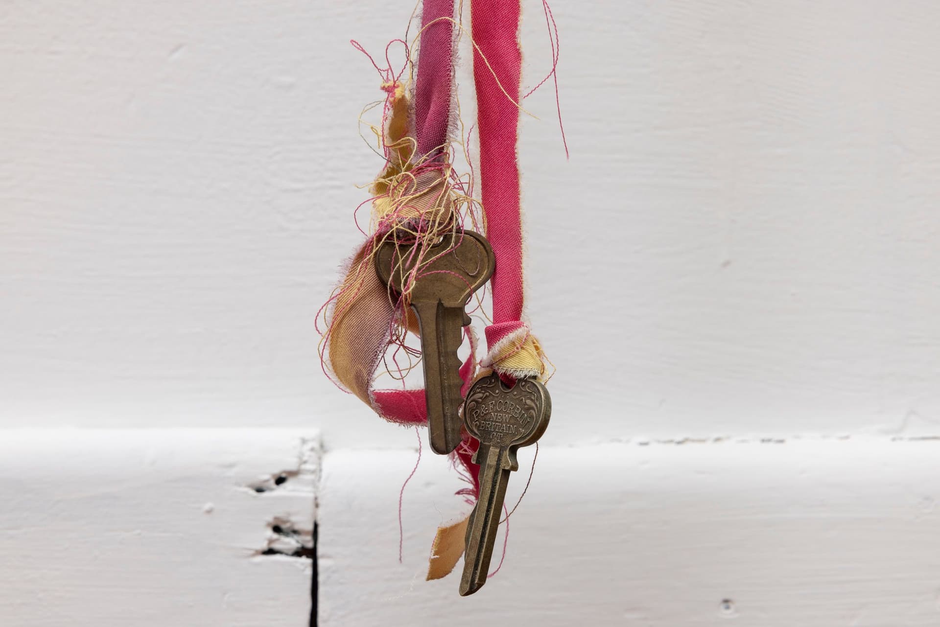 Marisa Kriangwiwat Holmes. Bells Ring (Detail), 2024. Iron, door locks, ceramic bells and fence curls, keys, hand-dyed fabric, wooden peg. 83 × 80 inches.