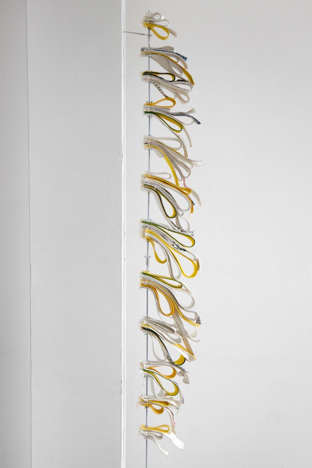 Bronson Smillie. Skewer #1, 2022. Nylon, bar rags, wing nuts, steel rod. 72 × 9 inches.